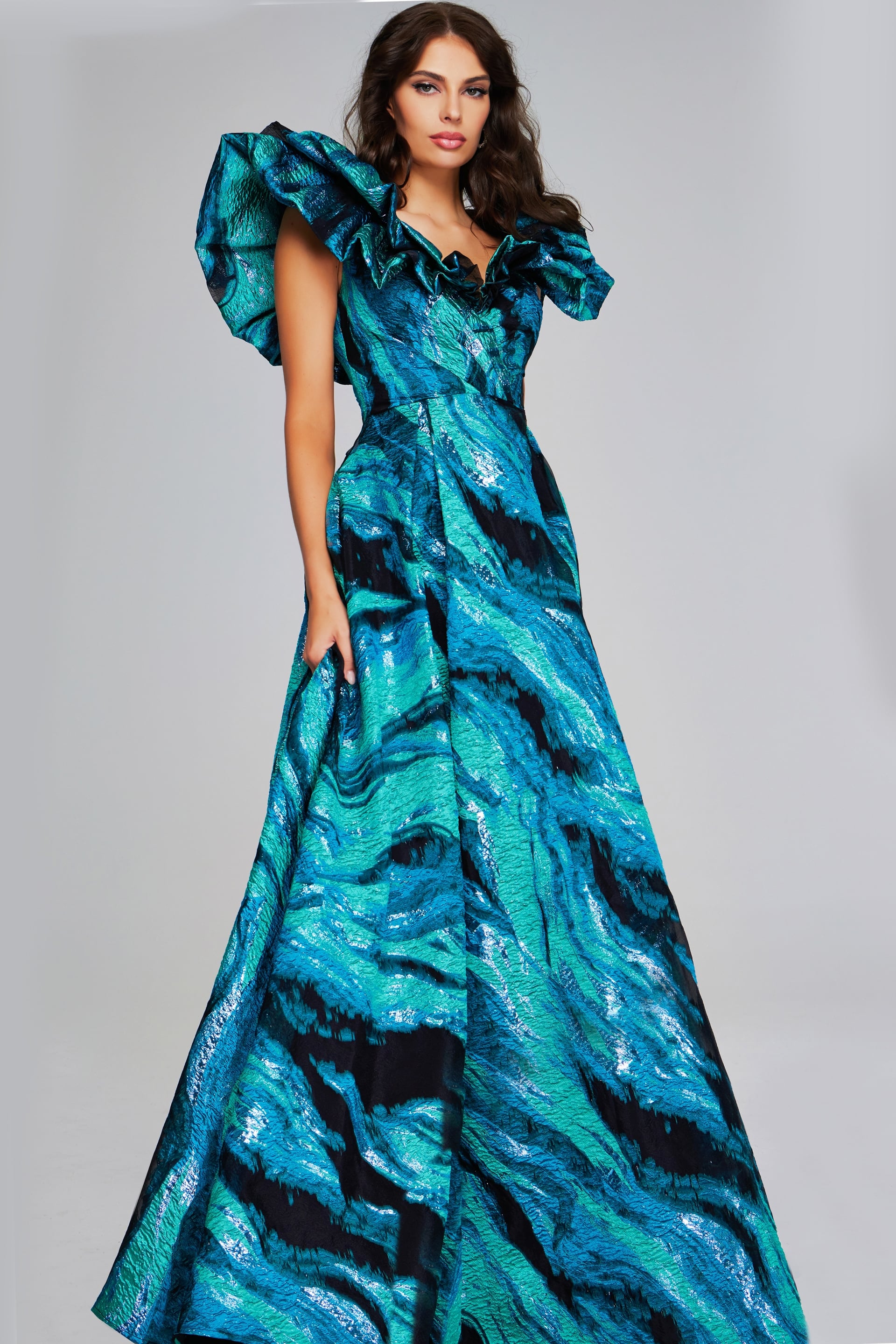 40696-TEALMULTI-2011.jpg Model wearing Jovani 40696 blue gown with V-neckline and ruffled sleeves, front view.
