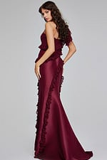 Model wearing Jovani 40751 burgundy one-shoulder gown with ruffles, back view.