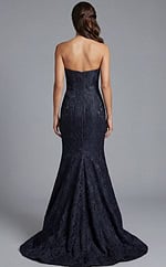 Back view of strapless textured gown with smooth bodice and flared hem
