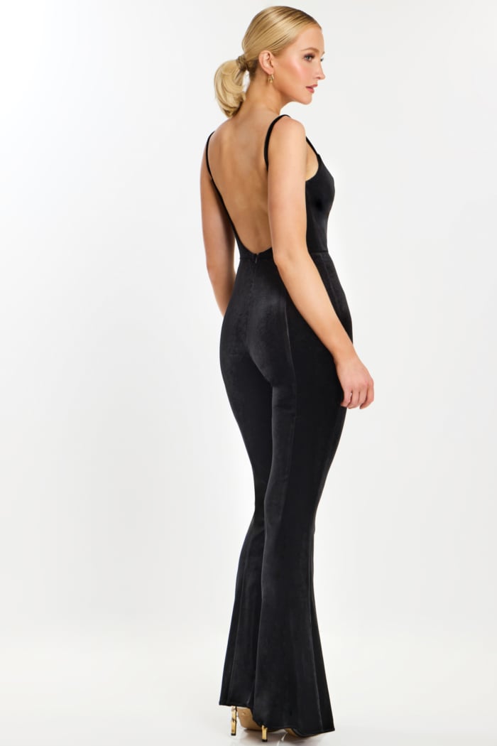 Side angle of flared black velvet jumpsuit showing backless detail