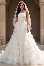 Front view of strapless bridal gown with dramatic layered tulle skirt