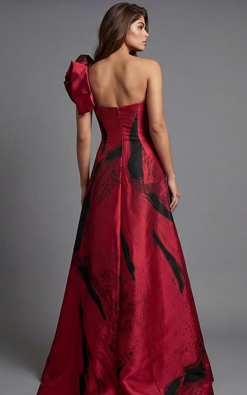 Strapless gown with dramatic red and black abstract pattern and statement shoulder bow