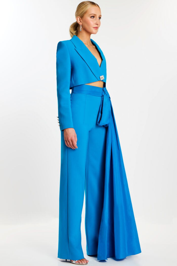 Side view of peacock blue pantsuit with satin sash and rhinestone button