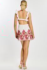 Back view of mini dress featuring open back and vibrant floral hem embroidery