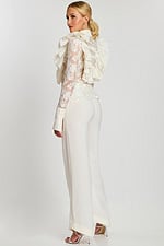 back view of a ruffled top and white pants