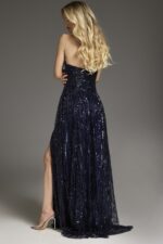 Model wearing Jovani 43386 navy gown, showing back and slit
