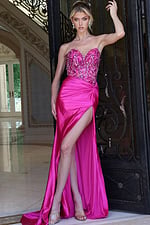 fuchsia beaded corset dress with high slit - front full body, raised arm on ornate gate, leg slit