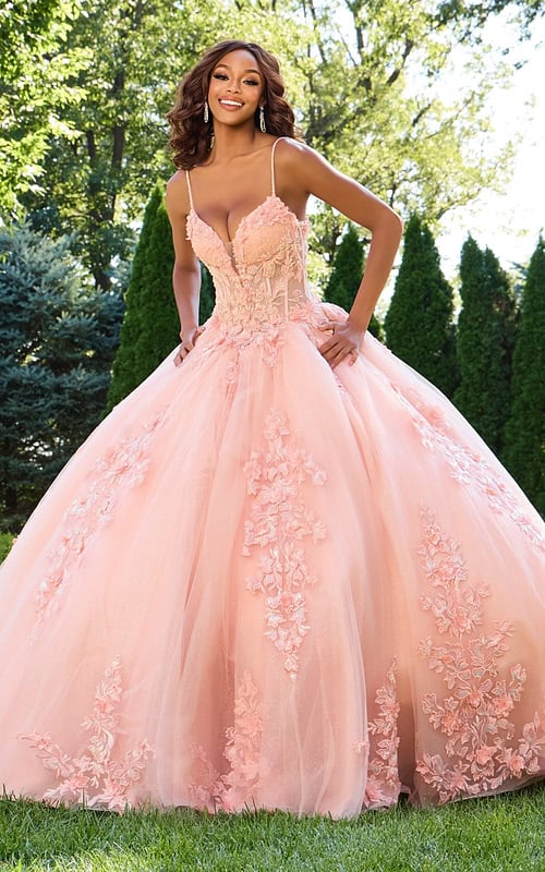 Model wearing Jovani 43431 blush gown with floral appliqués, front view.