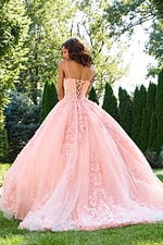 Model wearing Jovani 43431 blush gown, back view with lace-up design.