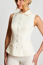 Close-Up Of Ivory Sleeveless Top With Fabric Buttons And Notched Flap Pockets