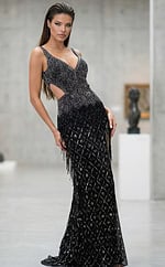 Angled view of a fitted gown with side cutouts, detailed bead patterns, and a floor length silhouette