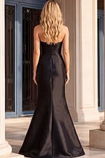 Back view of a black strapless formal gown showcasing a sleek satin finish, fitted bodice, and flared mermaid skirt with an elegant train.
