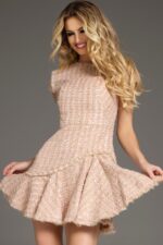 Model wearing Jovani 44192 blush short dress with high neckline and cap sleeves, playful pose.