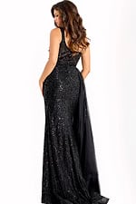 Black sequin gown with sheer bodice and draped chiffon overlay.