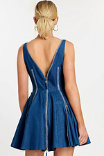 Back view showing V-cut back and central zipper detail on flared denim dress