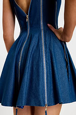 Close-up of back zipper detail and structured flare in deep blue denim