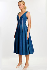 Side angle showing the flared A-line skirt and zippered seams of the denim dress