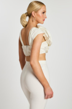 Side-back angle highlighting floral texture and fitted silhouette of the off-white ensemble