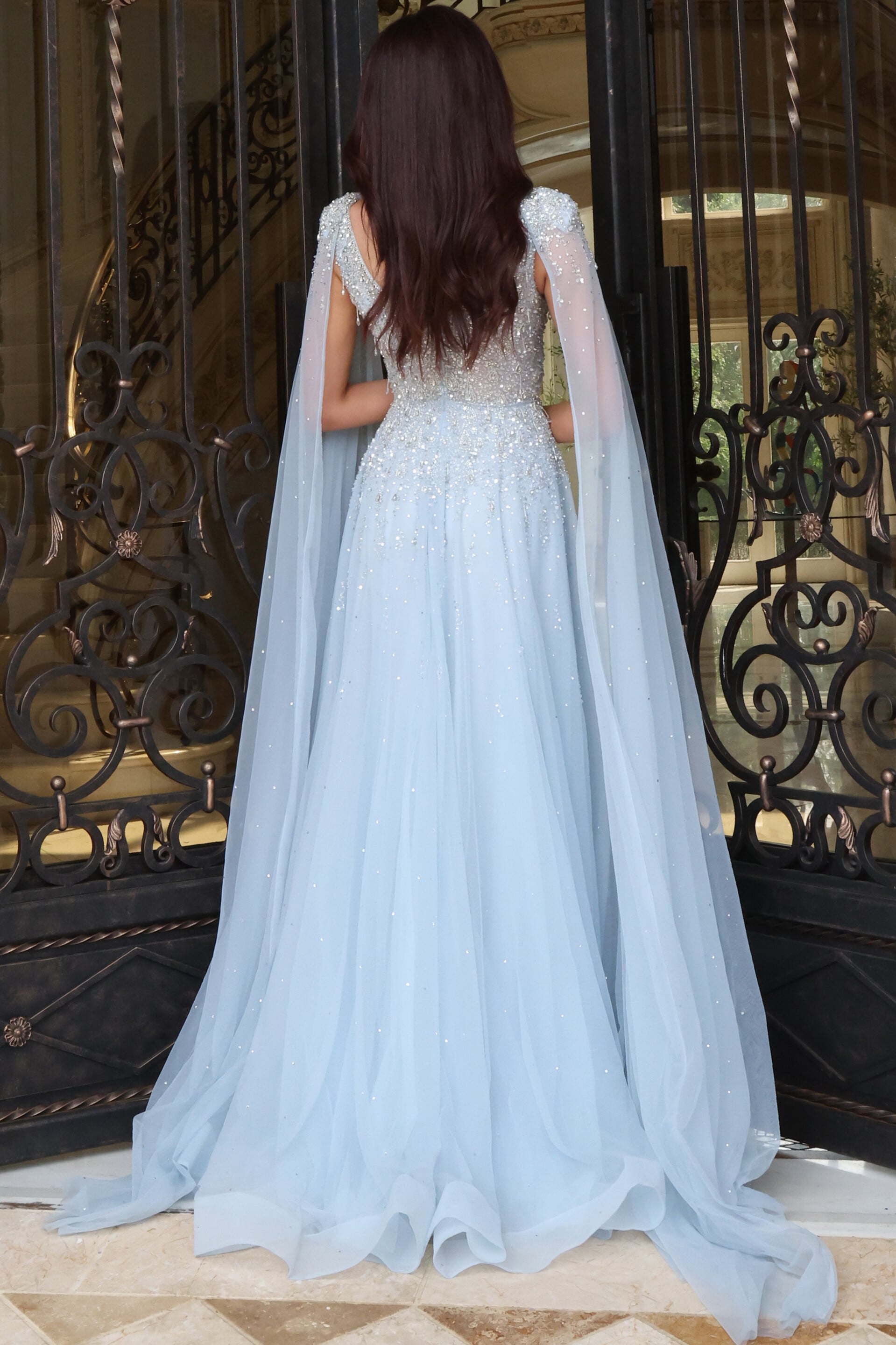 Light blue beaded gown with sheer cape sleeves and full tulle skirt, back view