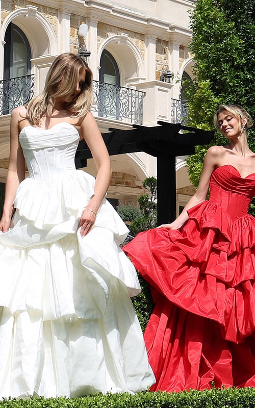 strapless layered ruffle ball gown - two girls front, hair covering face smiling fanning skirt
