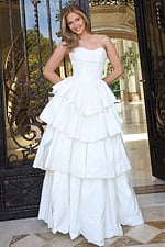 white strapless layered ruffle ball gown - front full body, blonde hair smiling hands behind