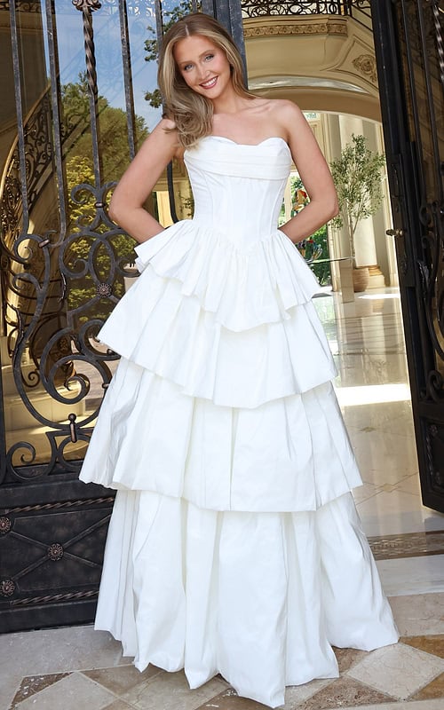 white strapless layered ruffle ball gown - front full body, blonde hair smiling hands behind