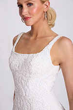 Close-up of bodice showing floral lace texture and subtle beading on neckline