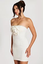 Angled view of strapless off-white cocktail dress with crystal rose