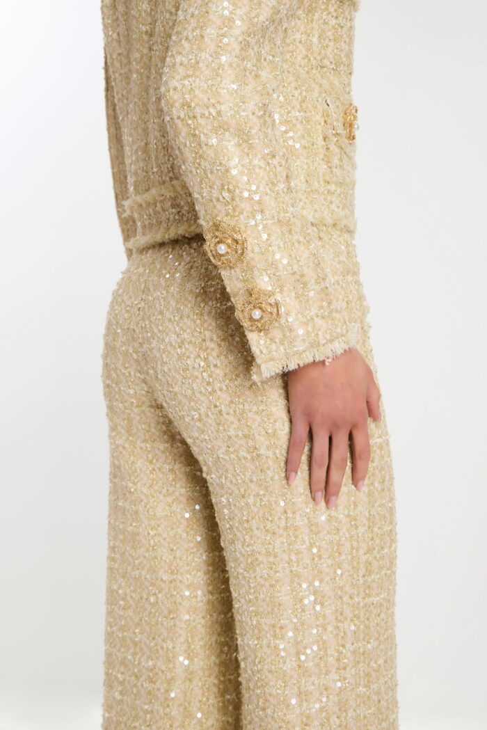 Close-up of sleeve cuff detailing with pearl and bead buttons