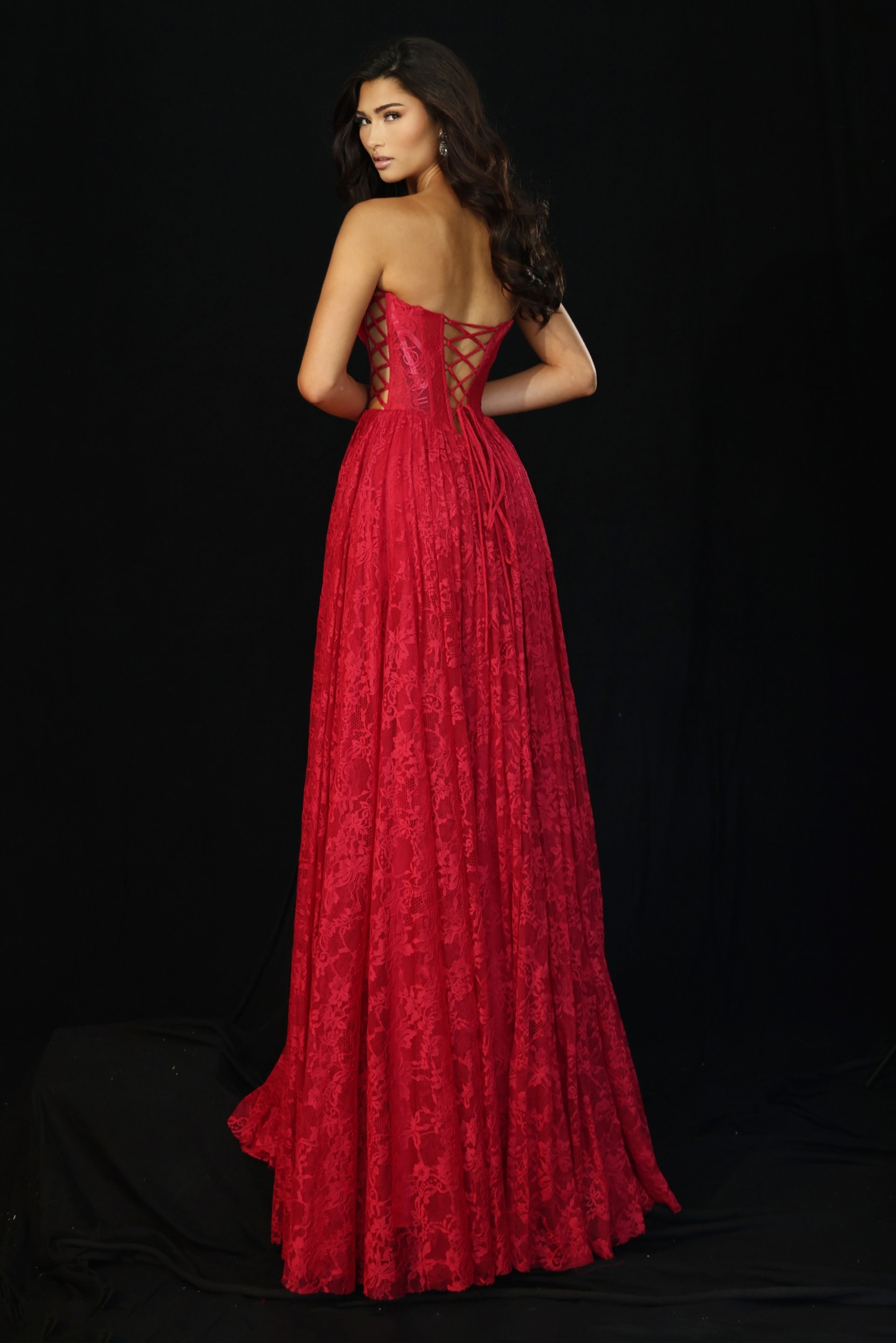 Red lace evening gown featuring lace-up back and flowy skirt