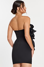 Side view of form-fitting strapless mini dress with oversized ruffle detailing