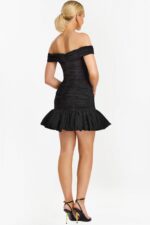 Side angle of ruched black dress with flared ruffle hem