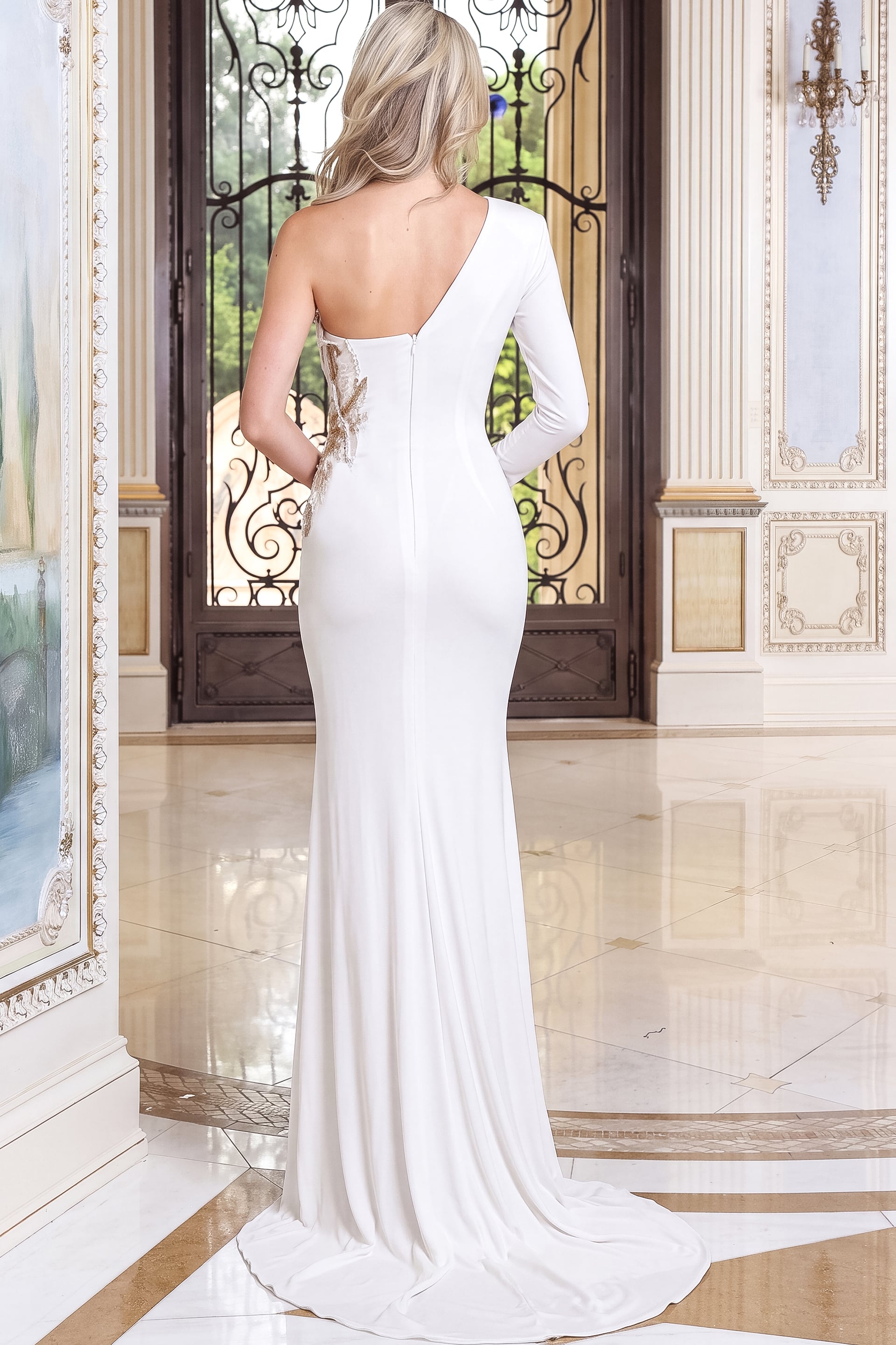 back view of white crepe plunging sheath gown with one long sleeve and high slit