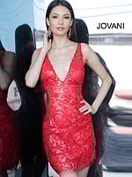 Model wearing Jovani 4552 red dress with floral sequins, front view with reflection