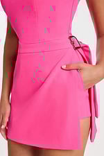 Close-up of waist and hand-in-pocket detail with gold buckle on hot pink romper dress.