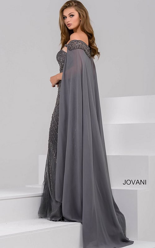 Model wearing Jovani 45566 gray gown with a view of the back and cape-like sleeves.