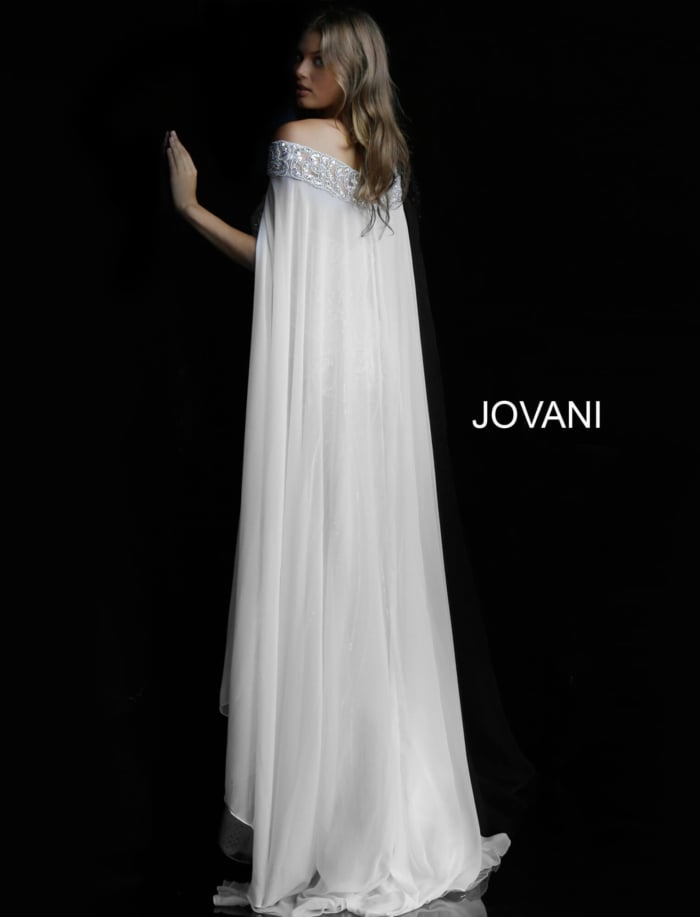Model wearing Jovani 45566 ivory gown with a view of the back and flowing cape.