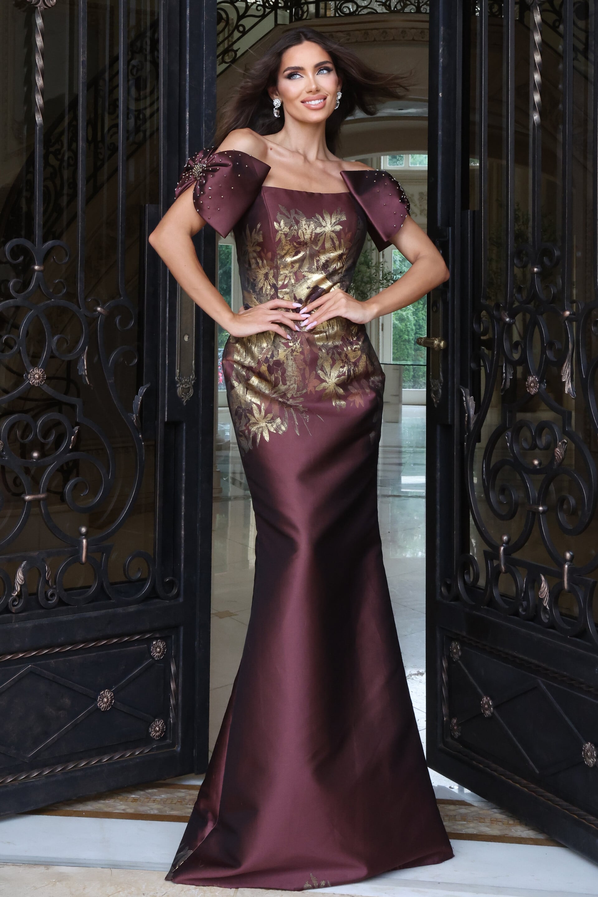 Burgundy off-the-shoulder mermaid gown with metallic gold floral print and puff sleeves, front view