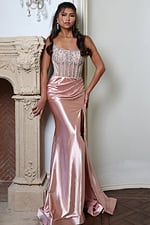 blush satin dress with beaded corset - front full body, resting hand on ornate fireplace