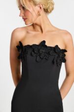 Detail of floral beading and sculpted bust on elegant black dress