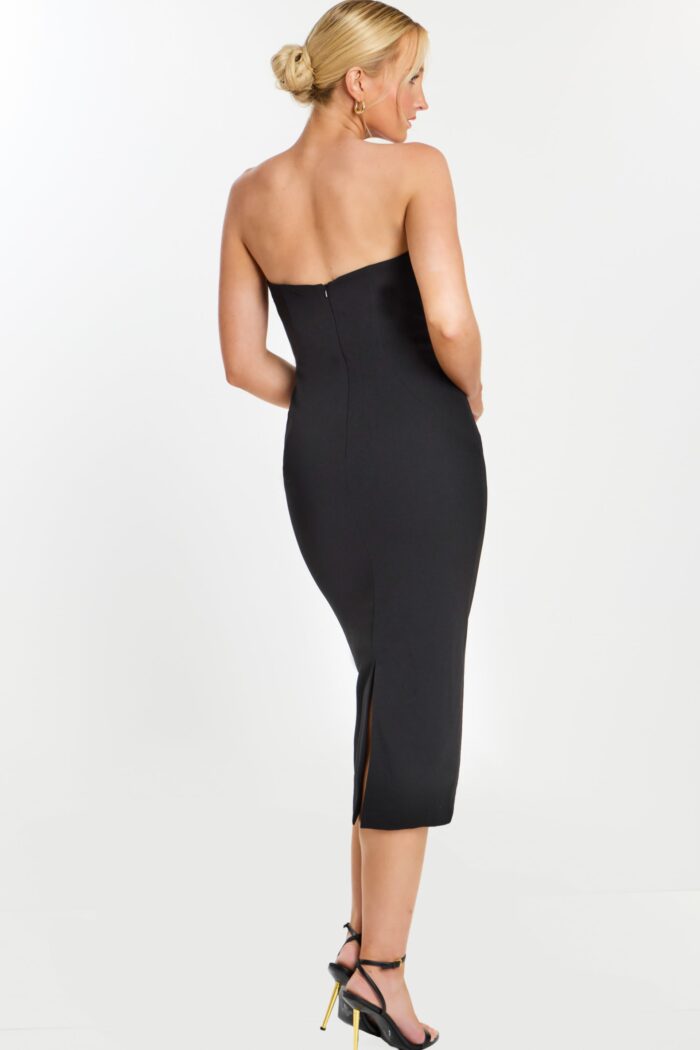 Back view of sleek black midi dress with slit and zipper closure