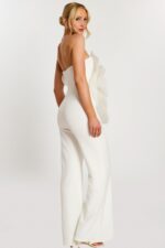 Over-the-shoulder pose showing back and side of white floral jumpsuit