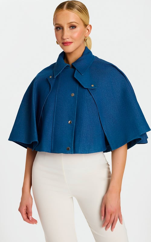 Model Wearing Cropped Denim Cape Jacket with Button Front and Wide Collar over White Pants