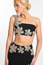 Close-up of crystal floral embellishments on black one shoulder crop top