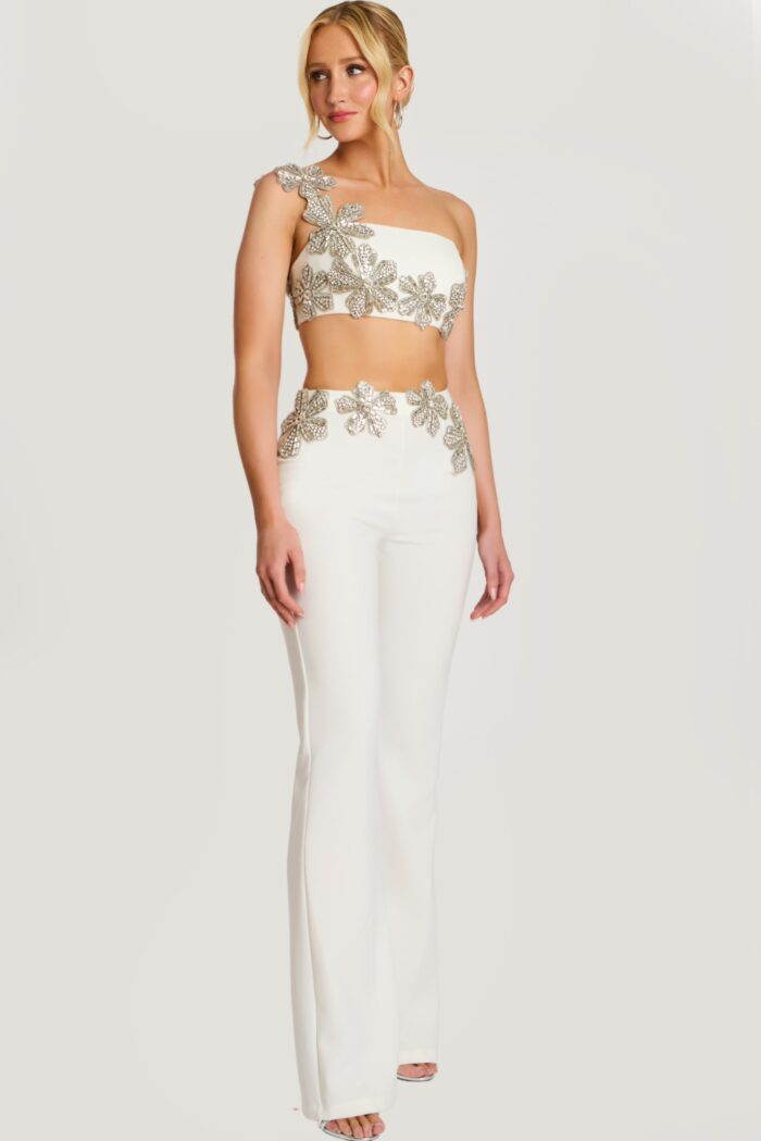 Close-up of beaded floral crop top with asymmetrical strap on ivory pantsuit
