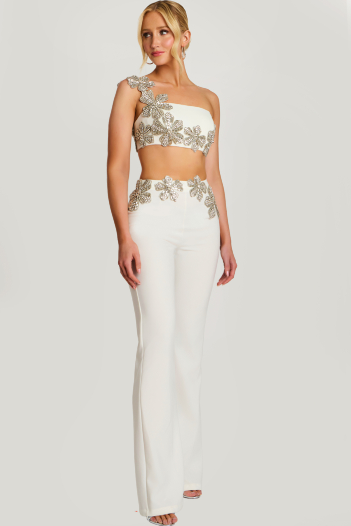 Close-up of beaded floral crop top with asymmetrical strap on ivory pantsuit