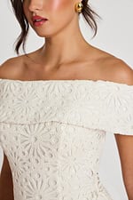 Close-up of floral lace texture and fold-over neckline on off-white dress