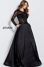 Model wearing Jovani 46066 black gown with full skirt and sheer sleeves.