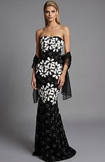 Front view of a strapless black floral brocade column gown