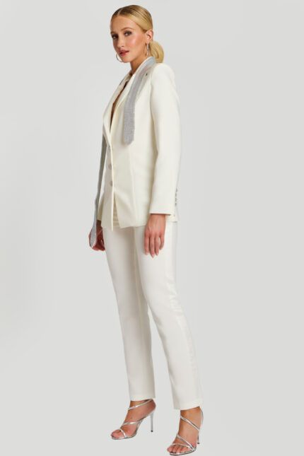 Side angle of white blazer pantsuit featuring shimmering lapel detail